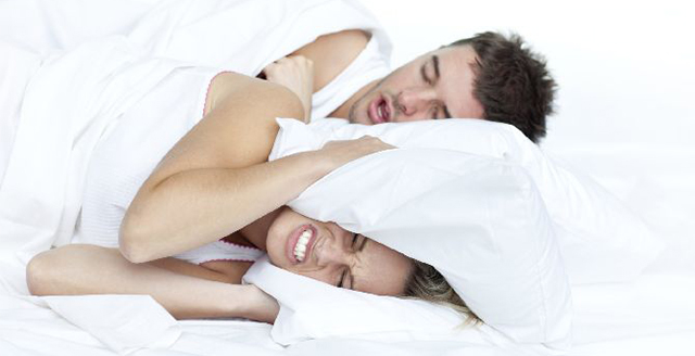 Couple in bed while the woman is trying to sleep